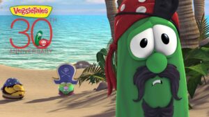 VeggieTales characters on a sunny beach celebrating the 30th anniversary, with a large '30th Anniversary' logo in the sky.