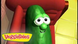 Larry the Cucumber from VeggieTales smiles from a red chair, logo in the corner.