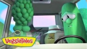 VeggieTales scene with two anthropomorphic vegetables inside a car: a green cucumber at the wheel and a cluster of grapes on the left; VeggieTales logo bottom left.