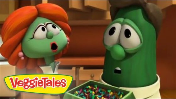 Two VeggieTales characters, a surprised tomato and a green pea, stand in a kitchen looking startled, with a bowl of colorful candies and the VeggieTales logo visible.