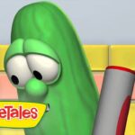 Larry the Cucumber from VeggieTales looks at a large marker in a colorful tiled set, logo visible in the corner.