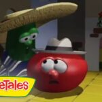 Tomato character wearing a hat looks surprised as a green veggie behind him leans over in a kitchen-like room; VeggieTales logo in corner.