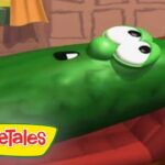 Green VeggieTales cucumber character lying down, eyes open, with the VeggieTales logo in the corner.