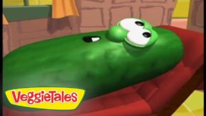 Green VeggieTales cucumber character lying down, eyes open, with the VeggieTales logo in the corner.