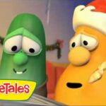 Two VeggieTales characters, a green cucumber and an orange carrot wearing a Santa hat, in a Christmas setting with the VeggieTales logo in the corner.