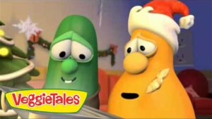 Two VeggieTales characters, a green cucumber and an orange carrot wearing a Santa hat, in a Christmas setting with the VeggieTales logo in the corner.