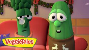 Two VeggieTales characters sit on a pink sofa, a broccoli with a monocle and a green pepper wearing a brown scarf, looking surprised.**(informative)