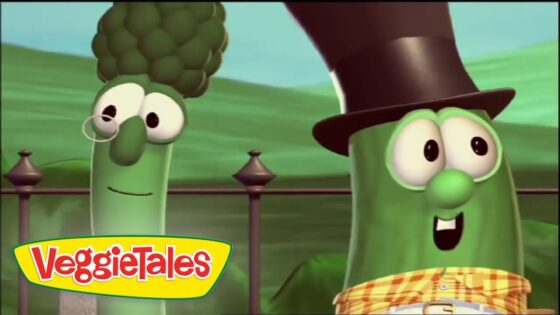 Two green VeggieTales characters stand outdoors, one with a monocle and broccoli top, the other wearing a tall hat and checkered scarf, smiling at the camera.