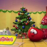 Animated VeggieTales characters celebrate Christmas around a decorated tree with ornaments and gifts.