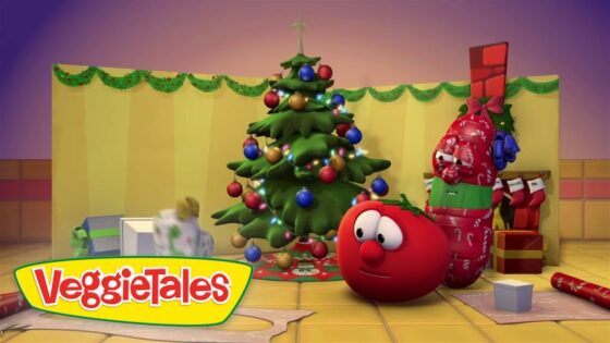 Animated VeggieTales characters celebrate Christmas around a decorated tree with ornaments and gifts.