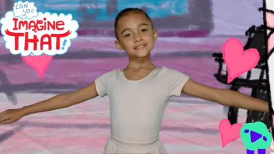 Young girl in a white leotard with arms extended, posing in front of a colorful mural reading 'Imagine That!' with pink hearts nearby.