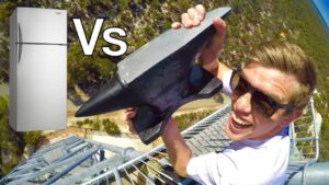 Thumbnail showing a man on a metal tower gripping a large metal tool, with a refrigerator image on the left and a bold 'Vs' between them to indicate a comparison video.