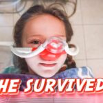 Young girl in a hospital bed wearing an oxygen/nasal mask, with a bold 'SHE SURVIVED!' caption across the image.