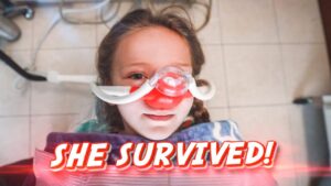 Young girl in a hospital bed wearing an oxygen/nasal mask, with a bold 'SHE SURVIVED!' caption across the image.