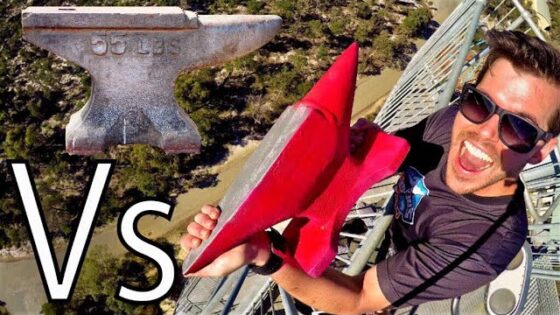 Man wearing sunglasses on a tall metal structure, smiling while holding a red rocket toy; large 'VS' text on left.