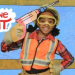 Child in a safety vest and goggles holds a large pink toy syringe beside the 'Imagine That!' graphic.
