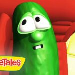 Green pickle-like VeggieTales character with a startled expression seated in a red chair, VeggieTales logo visible in the bottom-left corner.