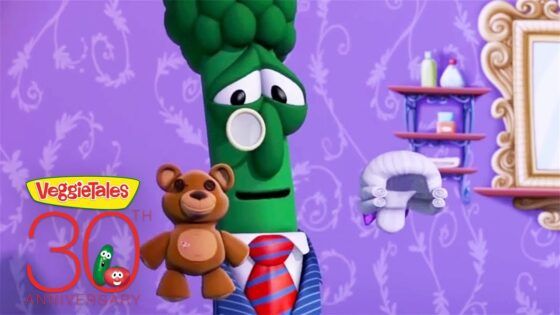 VeggieTales 30th anniversary promo featuring a green broccoli character in a suit and red tie with a teddy bear against a purple patterned wall.