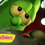 Close-up of a green VeggieTales character with big eyes, looking at a red flower; VeggieTales logo in corner.