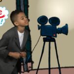 Young boy in a suit posing near a vintage film camera on a tripod in a studio with a speech bubble saying 'Can you imagine that!'