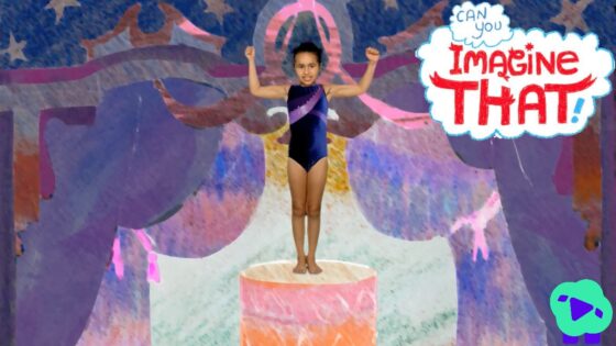Young girl in a navy leotard stands on a pink pedestal with arms raised on a colorful stage backdrop, with the 'Imagine That' logo visible.