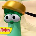 Larry the Cucumber from VeggieTales wearing a gold helmet in a desert setting.