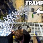 People on a tall metal platform dump a crate full of white balloons outward, creating a balloon spill below. A sign or graphic reading 'TRAMPOLINE' is visible in the corner.