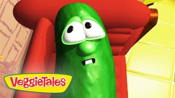 VeggieTales pickle character with wide eyes and a worried expression, sitting in a red chair.