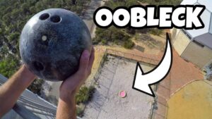 Person gripping a bowling ball high above a fenced courtyard, captured from a balcony; bold thumbnail text says OOBLECK.