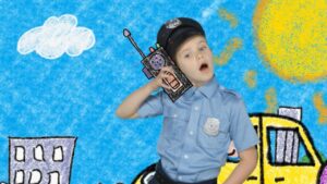 Boy in a police uniform talking into a toy radio against a bright crayon-drawn backdrop (blue sky, sun, buildings).
