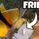 YouTube thumbnail showing a person on a high platform holding a yellow winged contraption, with a fridge on the ground below and the word FRIDGE in bold text.
