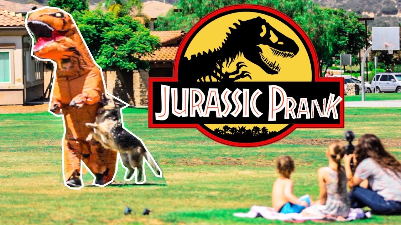 Thumbnail showing a giant dinosaur cutout overlapping a man in a park, with kids filming nearby and a large 'Jurassic Prank' logo in the center.