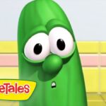 Green cucumber character from VeggieTales with a surprised expression in a colorful kitchen set (logo visible).