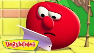 Red VeggieTales tomato character looks puzzled while holding a sheet of paper in a bright kitchen set.