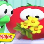 Green VeggieTales cucumber embraces a red tomato holding a bouquet of yellow flowers.