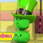 Three green vegetables stacked as a figure wearing a tall leprechaun hat with a clover, beside a red wall switch.