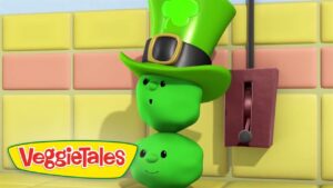 Three green vegetables stacked as a figure wearing a tall leprechaun hat with a clover, beside a red wall switch.