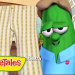Green VeggieTales cucumber in a blue shirt smiles beside a tall striped-pants prop in a cozy kitchen; VeggieTales logo bottom left.