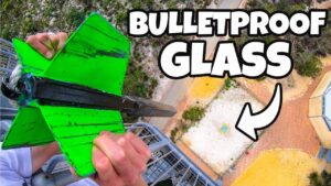 Thumbnail of a person striking bright green bulletproof glass on a high balcony, with bold 'BULLETPROOF GLASS' text overlay and a white arrow.
