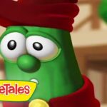 Close-up of a green VeggieTales character with a red hat and yellow logo in the corner.