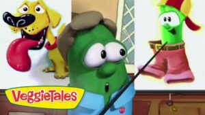 Green cucumber from VeggieTales in a blue shirt and brown hat, presenting a slide with a dog image; VeggieTales logo lower left.