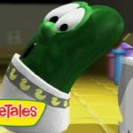 Green VeggieTales character tilts head and looks toward a computer screen in a bright, yellow-tiled room; VeggieTales logo shown bottom-left.