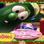 Larry the Cucumber from VeggieTales leans toward a pink birthday cake with presents nearby, inside a festive holiday border with the VeggieTales logo.