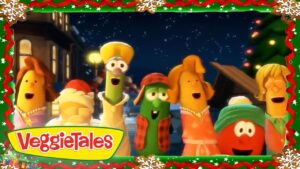Group of VeggieTales vegetables singing together at night during Christmas, with a festive border and the VeggieTales logo in the corner