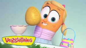 Animated VeggieTales character with blonde hair and big eyes holds a large yellow egg beside a pedestal; VeggieTales logo visible.