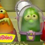 Three VeggieTales characters with large eyes in a futuristic control room; a green cucumber in a space helmet center, an orange veggie on the left and a red veggie on the right, VeggieTales logo in the corner.