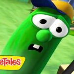 Larry the Cucumber from VeggieTales looks surprised with mouth open; green field and playground in the background, VeggieTales logo in the corner.