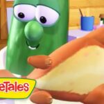 Green cucumber character from VeggieTales holding a sandwich bun, about to take a bite in a cozy kitchen scene with the logo visible in the corner