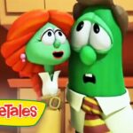 Two green veggie characters in a kitchen, a red-haired female and a green cucumber-like figure, look surprised as they stand near cabinets; VeggieTales logo in the bottom-left corner.