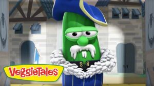 Green VeggieTales cucumber in a blue pirate outfit with a white fur collar, standing in a castle set with the VeggieTales logo.